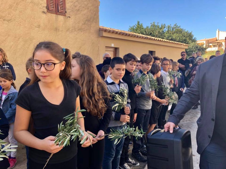 Le village de Lumiu recueilli autour de son monument aux morts Le village de Lumiu recueilli autour de son monument aux morts